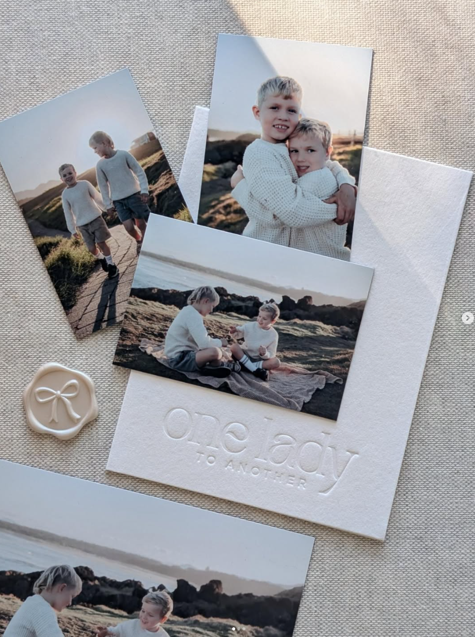 Three magnetic photos arranged over a debossed branded card with wax seal