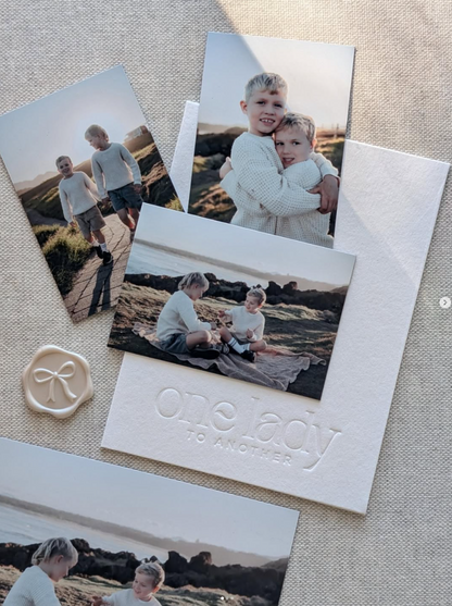 Three magnetic photos arranged over a debossed branded card with wax seal